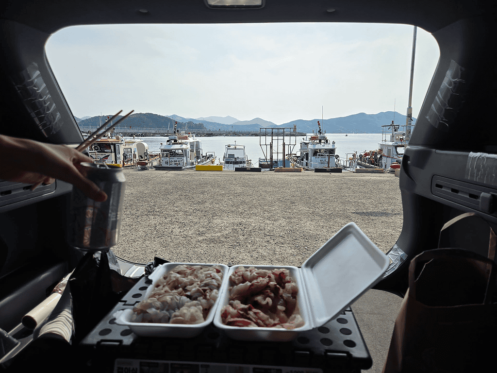 항구에서 즐기는 바다 풍경과 함께하는 간단한 식사 모습.